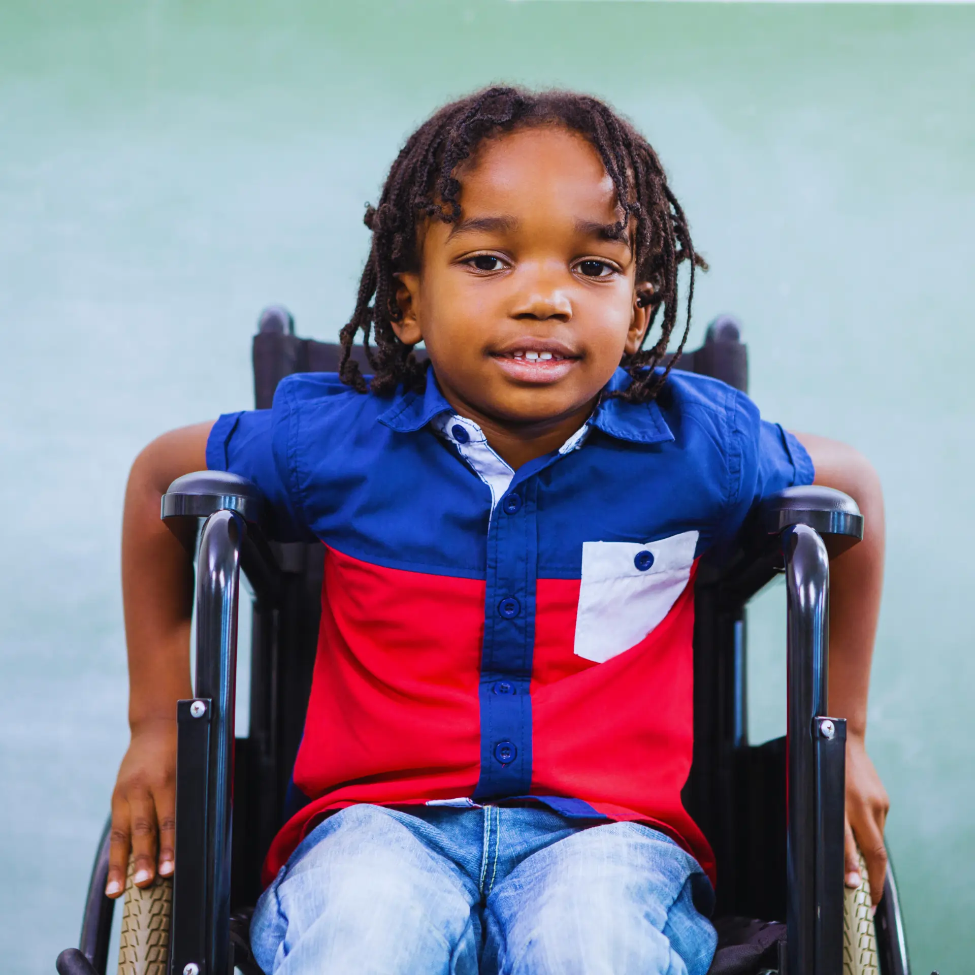 Smiling boy in a wheelchair receiving support at home.