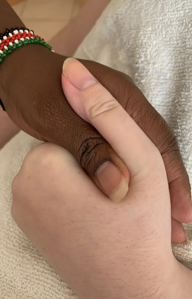 Close-up of two hands holding to represent compassionate and inclusive home care.