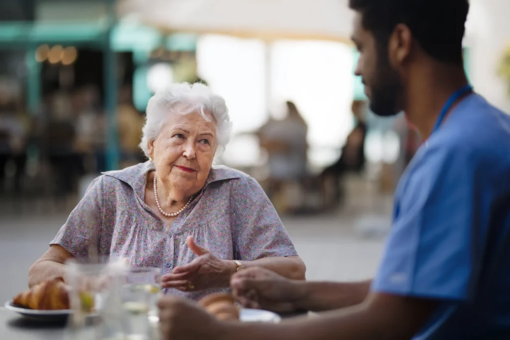 Smiling caregiver embracing elderly woman during respite care visit in Swindon