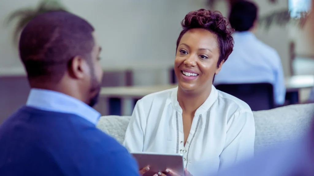 Smiling care manager in discussion with commissioner during a consultation.