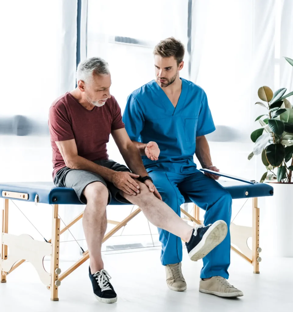 Senior male patient receiving post-operative leg rehabilitation from physiotherapist in Truro