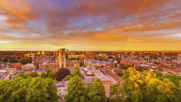 Panoramic view of Bristol city centre at sunset with a rainbow overhead