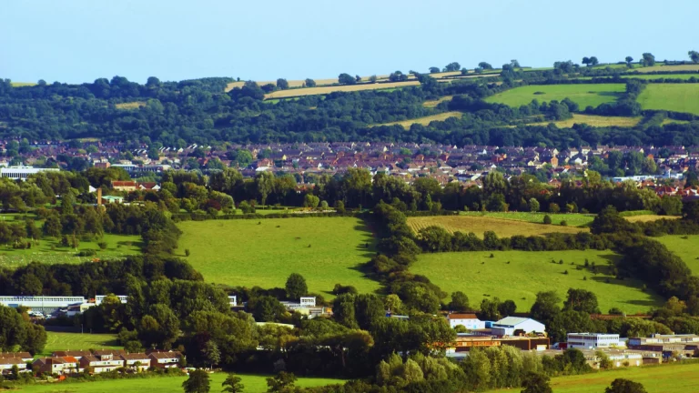 Rolling green countryside leading to a South West town, symbolising local home care reach